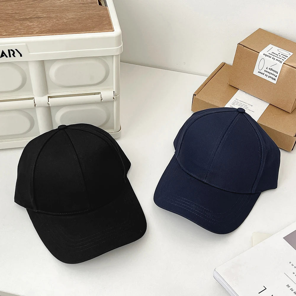 Two SecureShield EMF Blocking Baseball Caps displayed side by side on a flat surface, one in blue and the other in black, showcasing their design and color contrast.